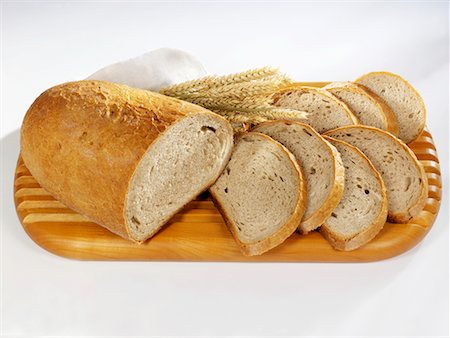 simsearch:659-02211575,k - Partly sliced loaf of bread on a wooden board Stock Photo - Premium Royalty-Free, Code: 659-02211575