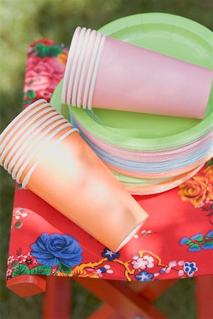 simsearch:659-02211785,k - Coloured paper cups and plates on folding stool in garden Fotografie stock - Premium Royalty-Free, Codice: 659-02211764