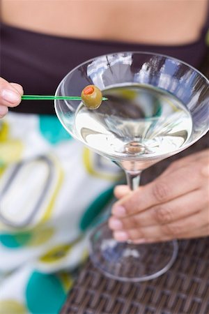 simsearch:659-06155164,k - Woman holding green olive on cocktail stick over Martini glass Foto de stock - Sin royalties Premium, Código: 659-02211767