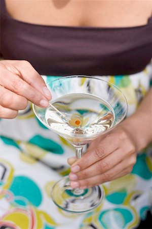 simsearch:659-06671060,k - Woman holding green olive on cocktail stick in Martini glass Foto de stock - Sin royalties Premium, Código: 659-02211768