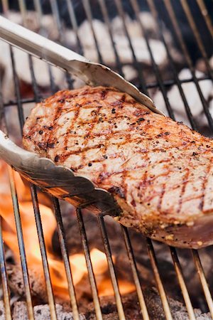 simsearch:659-02211839,k - Steak de boeuf sur un barbecue avec des pinces à barbecue Photographie de stock - Premium Libres de Droits, Code: 659-02211799