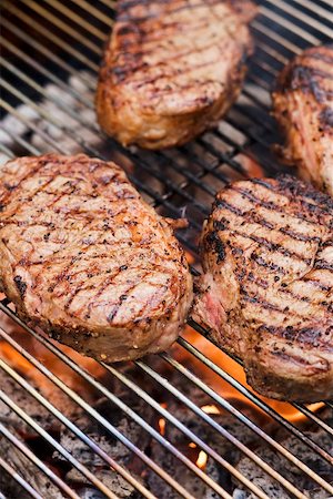 simsearch:659-03521388,k - Several beef steaks on a barbecue grill rack Foto de stock - Sin royalties Premium, Código: 659-02211801