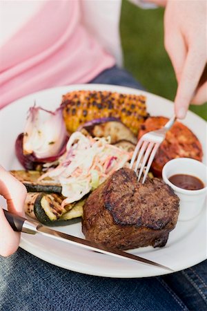 Seated woman eating grilled beef steak Stock Photo - Premium Royalty-Free, Code: 659-02211826