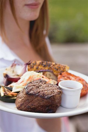 steak summer - Woman serving grilled beef steak with accompaniments Stock Photo - Premium Royalty-Free, Code: 659-02211827