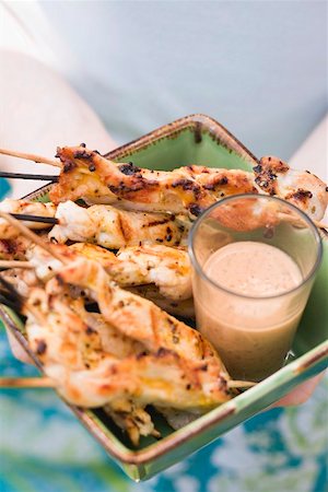 skewer - Woman holding grilled satay with dip Stock Photo - Premium Royalty-Free, Code: 659-02211833