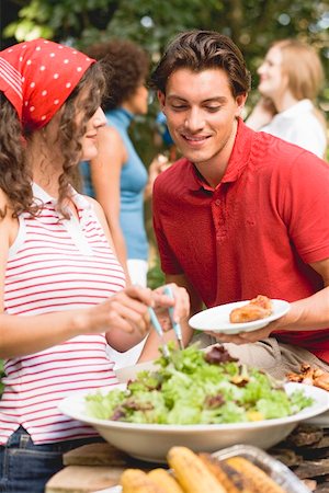 simsearch:659-02212589,k - Young woman serving green salad at a barbecue Stock Photo - Premium Royalty-Free, Code: 659-02211846
