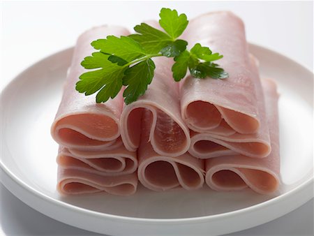sliced ham rolls - Ham rolls garnished with parsley Foto de stock - Sin royalties Premium, Código: 659-02211874