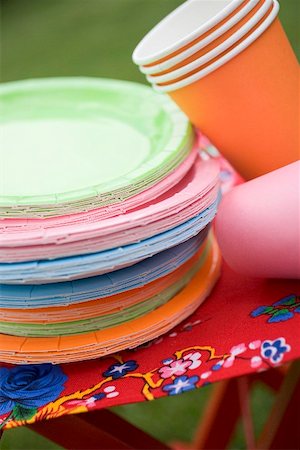 Coloured paper cups and plates on folding stool in garden Stock Photo - Premium Royalty-Free, Code: 659-02212036
