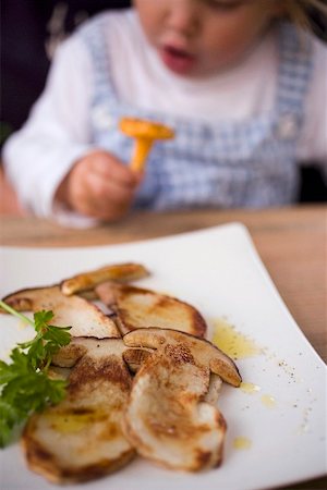 sliced mushroom - Fried cep slices, child with chanterelle behind Foto de stock - Sin royalties Premium, Código: 659-02212235