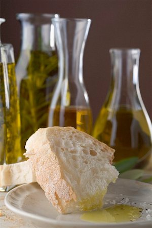 White bread with olive oil, bottles of oil in background Stock Photo - Premium Royalty-Free, Code: 659-02212320