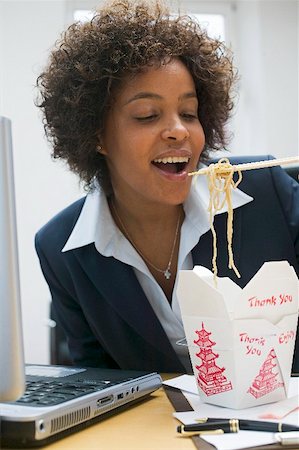 Woman in office eating Asian noodle dish Stock Photo - Premium Royalty-Free, Code: 659-02212378