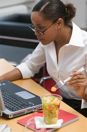 simsearch:659-02212739,k - Woman eating fruit salad in the office Foto de stock - Sin royalties Premium, Código: 659-02212388