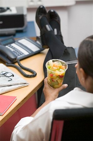 fruitsalad takeaway - Woman eating fruit salad in the office Stock Photo - Premium Royalty-Free, Code: 659-02212389