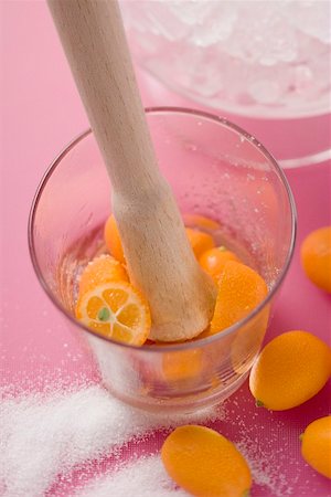Making a cocktail with kumquats (crushing kumquats in a glass) Stock Photo - Premium Royalty-Free, Code: 659-02212409