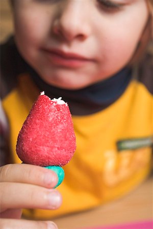 simsearch:659-01858229,k - Child holding a marzipan strawberry with a bite taken Fotografie stock - Premium Royalty-Free, Codice: 659-02212474