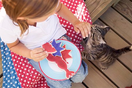 sitting aerial view - Small girl with partly-eaten cookie and cat (USA) Stock Photo - Premium Royalty-Free, Code: 659-02212508