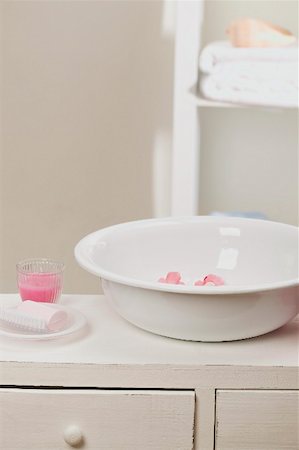 Wash bowl with flowers, soap, candle in glass in bathroom Fotografie stock - Premium Royalty-Free, Codice: 659-02212526