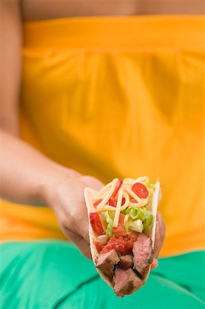 simsearch:659-03527106,k - Femme tenant un taco remplis de boeuf, salade et fromage Photographie de stock - Premium Libres de Droits, Code: 659-02212521
