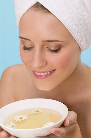 Woman with her hair wrapped in a towel, smelling herb tea Stock Photo - Premium Royalty-Free, Code: 659-02212536