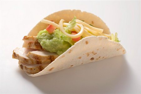 Folded tortilla filled with chicken, guacamole and cheese Foto de stock - Sin royalties Premium, Código: 659-02212556
