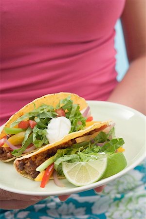 simsearch:659-03527105,k - Woman holding plate with two tacos Foto de stock - Royalty Free Premium, Número: 659-02212563