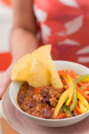 simsearch:659-03536211,k - Femme au service de chili con carne avec nachos et poivrons Photographie de stock - Premium Libres de Droits, Code: 659-02212584