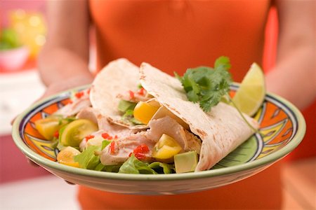 Woman serving plate of filled tortillas Stock Photo - Premium Royalty-Free, Code: 659-02212587