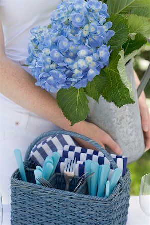 Woman decorating table in garden with vase of flowers Stock Photo - Premium Royalty-Free, Code: 659-02212633