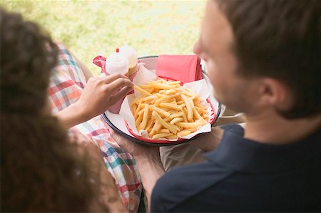 eating fries - Couple eating chips in garden Stock Photo - Premium Royalty-Free, Code: 659-02212663