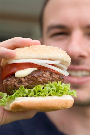 Man holding large hamburger Stock Photo - Premium Royalty-Free, Code: 659-02212704