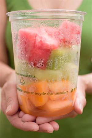 fruitsalad takeaway - Woman holding plastic tub of diced melon Stock Photo - Premium Royalty-Free, Code: 659-02212733