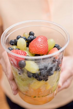 simsearch:659-02212762,k - Woman holding plastic tub of fruit salad Stock Photo - Premium Royalty-Free, Code: 659-02212748