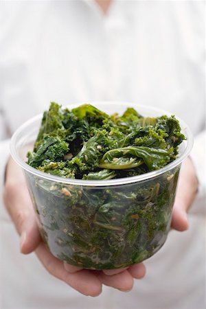 simsearch:659-02212761,k - Woman holding plastic tub of cooked kale Stock Photo - Premium Royalty-Free, Code: 659-02212761