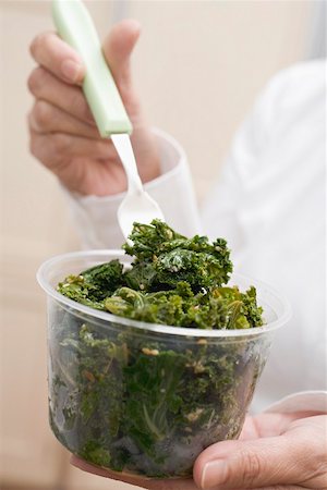 simsearch:659-02212753,k - Woman eating cooked kale out of plastic tub Stock Photo - Premium Royalty-Free, Code: 659-02212762