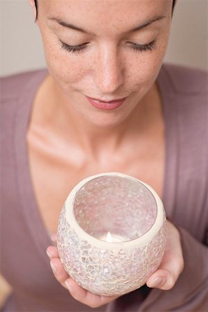 Woman holding candle in glass holder Fotografie stock - Premium Royalty-Free, Codice: 659-02212838