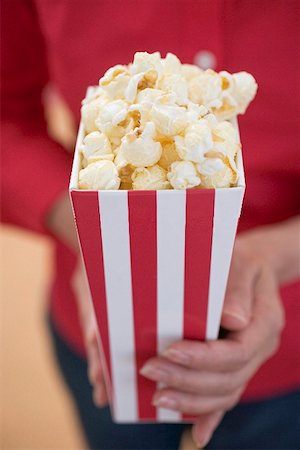 Woman holding popcorn in striped box (4th of July, USA) Stock Photo - Premium Royalty-Free, Code: 659-02212849