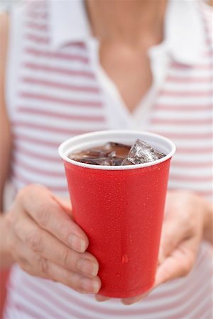 simsearch:659-03524301,k - Woman holding beaker of cola with ice cubes Fotografie stock - Premium Royalty-Free, Codice: 659-02212859