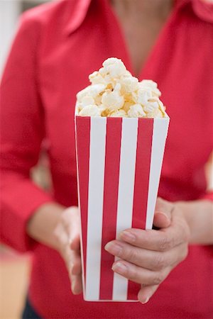 Woman holding popcorn in striped box (4th of July, USA) Stock Photo - Premium Royalty-Free, Code: 659-02212850