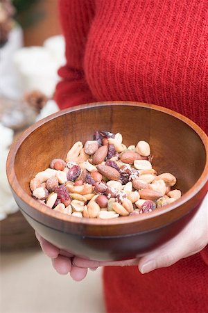Woman holding wooden bowl of nuts (Christmas) Stock Photo - Premium Royalty-Free, Code: 659-02212883
