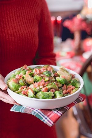 simsearch:659-02212898,k - Woman holding dish of Brussels sprouts with bacon (Christmas) Stock Photo - Premium Royalty-Free, Code: 659-02212897