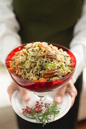 simsearch:659-02212898,k - Woman holding bowl of vegetable rice with pecans (Christmas) Stock Photo - Premium Royalty-Free, Code: 659-02212919