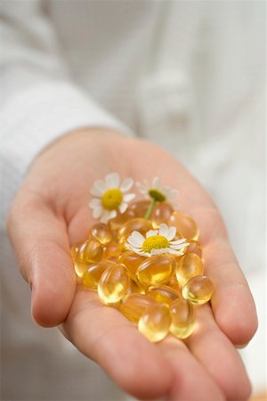 Hand holding vitamin capsules and chamomile flowers Stock Photo - Premium Royalty-Free, Code: 659-02212934