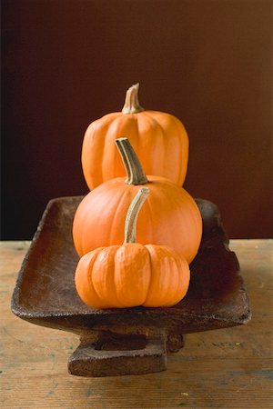 pumpkin still - Three orange pumpkins in wooden bowl Stock Photo - Premium Royalty-Free, Code: 659-02212949