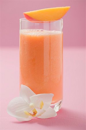 sweet fruits juice - Glass of mango smoothie with wedge of mango and orchid Stock Photo - Premium Royalty-Free, Code: 659-02213025