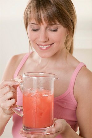 simsearch:659-03523361,k - Woman holding jug of fruit juice with ice cubes Stock Photo - Premium Royalty-Free, Code: 659-02213036