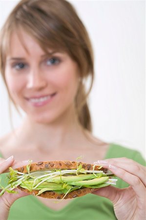 Woman holding healthy avocado and sprout sandwich Stock Photo - Premium Royalty-Free, Code: 659-02213058