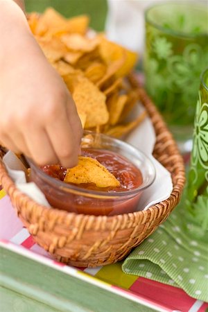 simsearch:659-07597105,k - Child's hand dipping tortilla chip in salsa Foto de stock - Royalty Free Premium, Número: 659-02213061