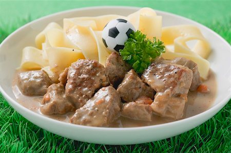 swiss cuisine - Zürcher Geschnetzeltes (veal dish) with ribbon pasta & toy football Stock Photo - Premium Royalty-Free, Code: 659-02213138