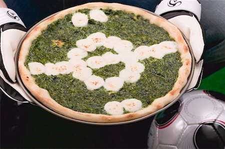 soccer ball as pizza - Hands holding spinach and mozzarella pizza, football Stock Photo - Premium Royalty-Free, Code: 659-02213171