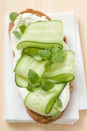 Yoghurt, cucumber slices and herbs on slice of bread Fotografie stock - Premium Royalty-Free, Codice: 659-02213262